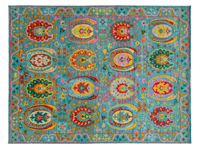 A rectangular turquoise blue area rug with a highly detailed, colorful traditional pattern featuring red, yellow, green, and pink floral and paisley motifs.
