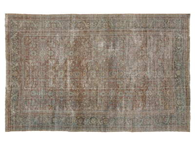 An antique-style distressed oriental rug with a faded traditional pattern in muted tones of brown, beige, gray, and blue, shown flat against a white background.