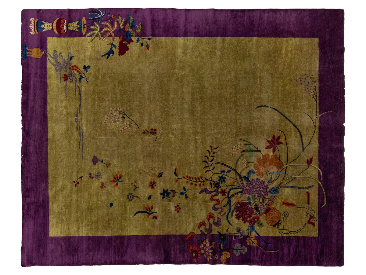 An antique Chinese rug with a wide purple border and a central gold-green field decorated with colorful floral and botanical motifs.