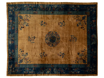 A traditional Chinese rug with a warm tan center field, a central medallion, and floral motifs, surrounded by a dark blue border.