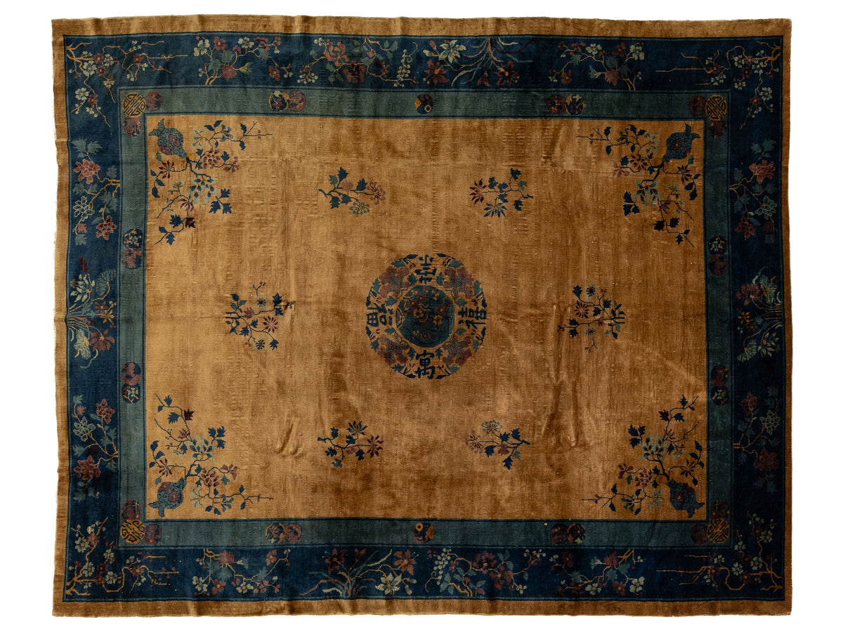 A traditional Chinese rug with a warm tan center field, a central medallion, and floral motifs, surrounded by a dark blue border.