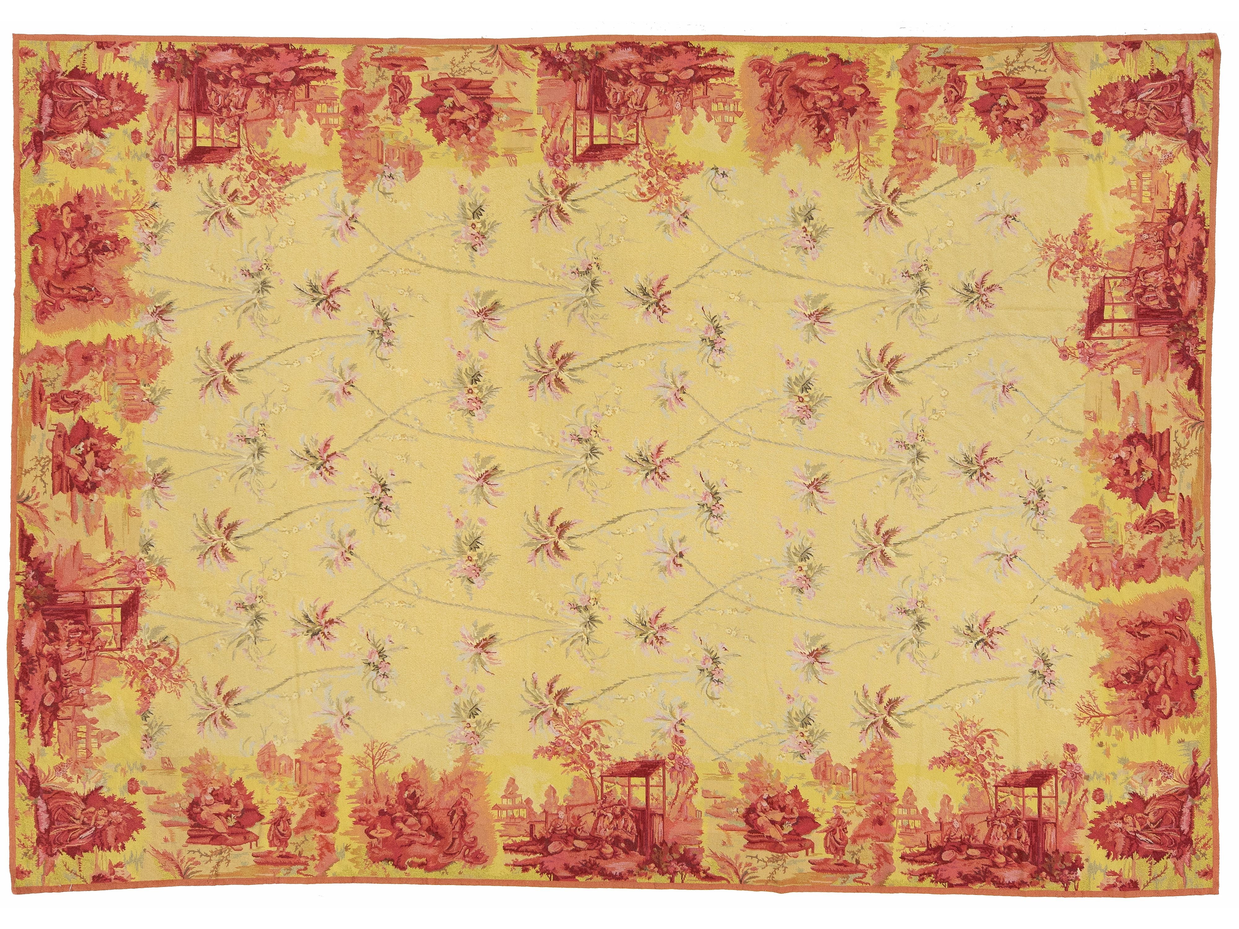 A rectangular textile or rug with a pale yellow base and a red toile-style border and scattered floral motifs, shown flat against a white background.