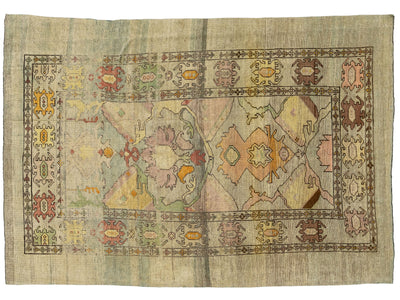 A rectangular vintage-style area rug with a distressed, faded medallion pattern in muted tones of beige, pink, green, orange, and brown.