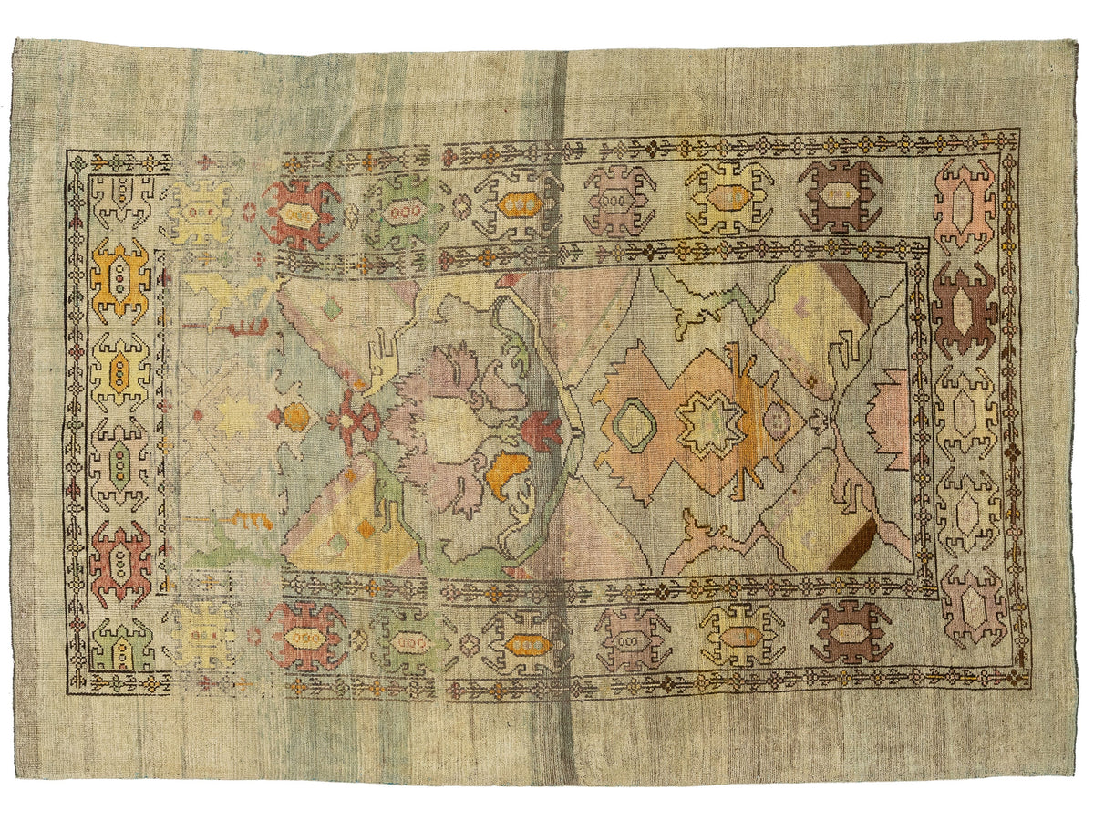 A rectangular vintage-style area rug with a distressed, faded medallion pattern in muted tones of beige, pink, green, orange, and brown.