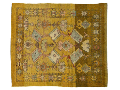 A rectangular vintage-style area rug with a mustard yellow base and an intricate central medallion pattern in muted pink, beige, light blue, and brown.