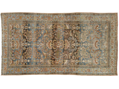 An antique-style rectangular area rug with a faded floral and medallion pattern in muted blue, beige, brown, and rust tones, shown flat against a white background.