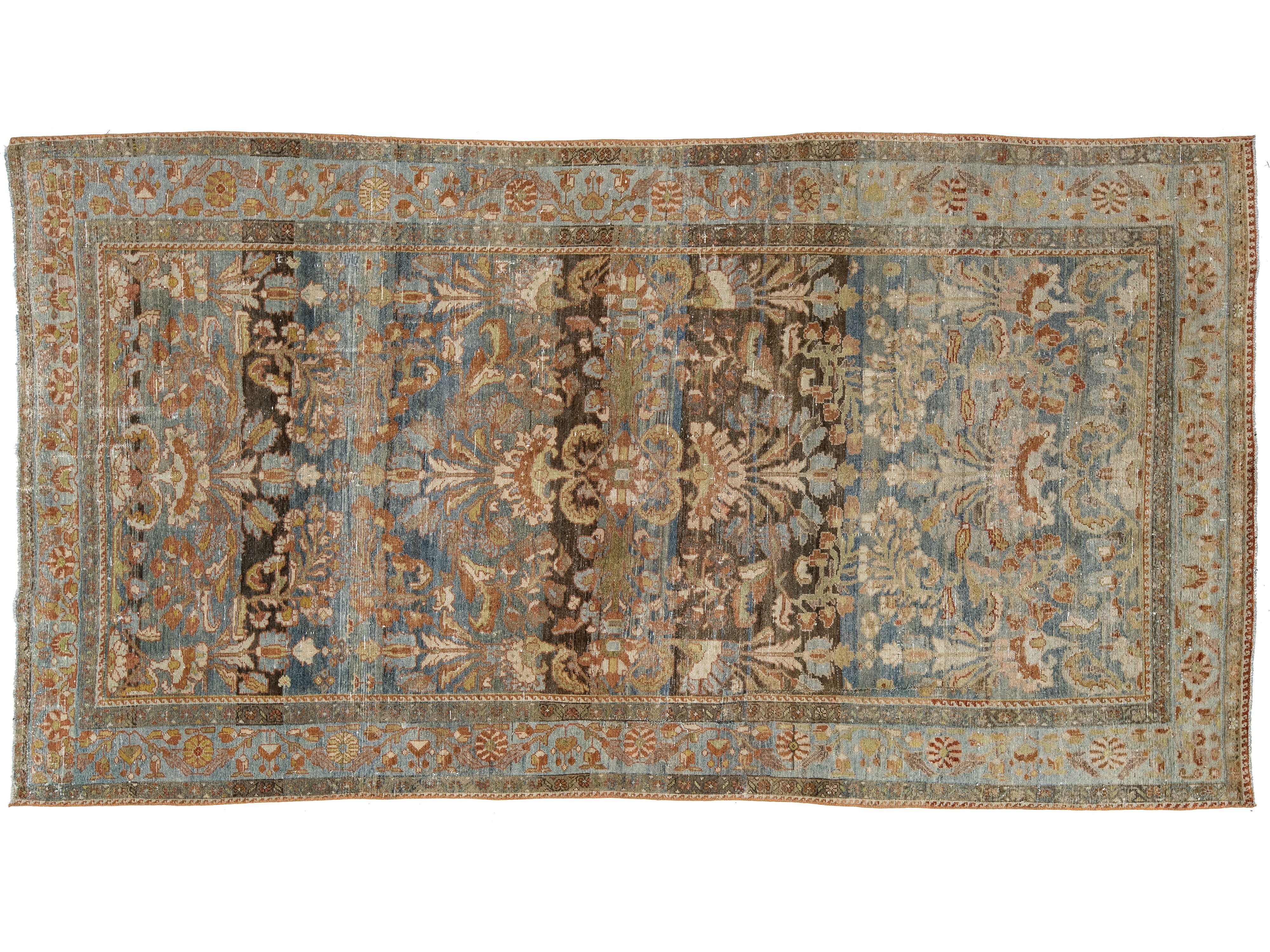 An antique-style rectangular area rug with a faded floral and medallion pattern in muted blue, beige, brown, and rust tones, shown flat against a white background.
