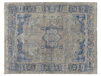 A rectangular oushak-style area rug with a distressed medallion pattern in muted blue, beige, and gray tones.