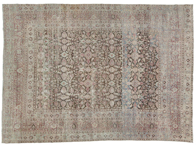 An antique-style oriental rug with a faded floral pattern, featuring a central field and multiple borders in muted tones of dusty pink, beige, gray, and light blue.