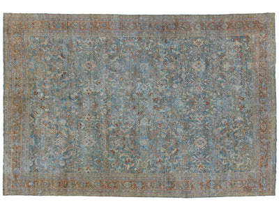 An antique-style oriental area rug with a distressed blue field, featuring a central medallion pattern and a rust-brown border.