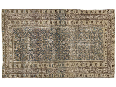 A rectangular vintage-style area rug with an intricate traditional pattern, featuring a central blue field surrounded by beige and brown borders.