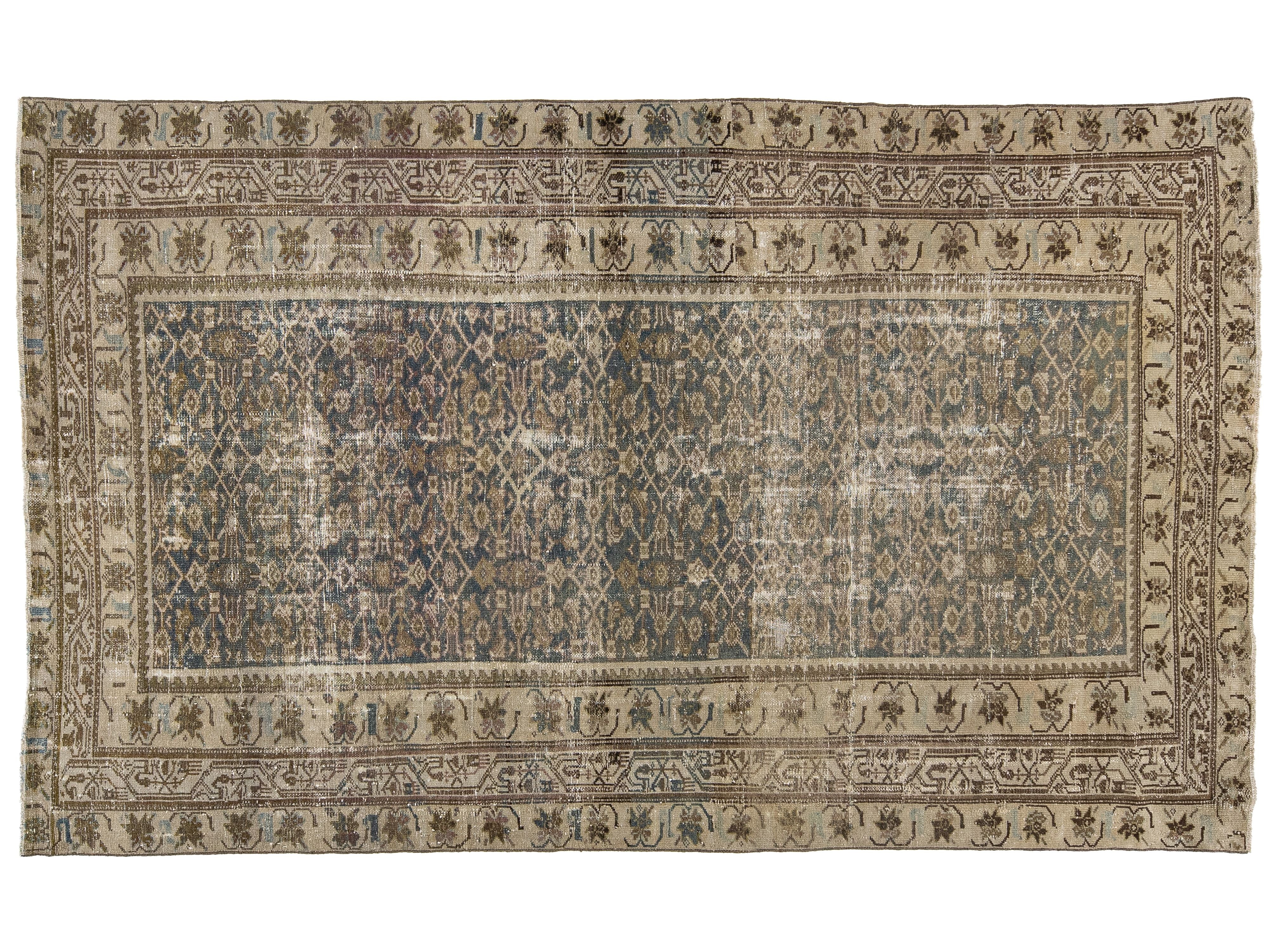 A rectangular vintage-style area rug with an intricate traditional pattern, featuring a central blue field surrounded by beige and brown borders.