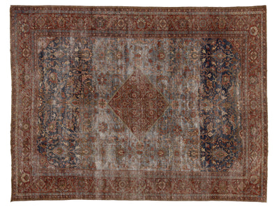 A distressed vintage-style oriental rug with a central diamond medallion, featuring a dusty blue-gray field, dark navy blue side panels, and a rust-brown border.