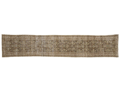 A long, narrow vintage-style area rug with an intricate traditional floral and geometric pattern in muted beige, brown, and gray tones.