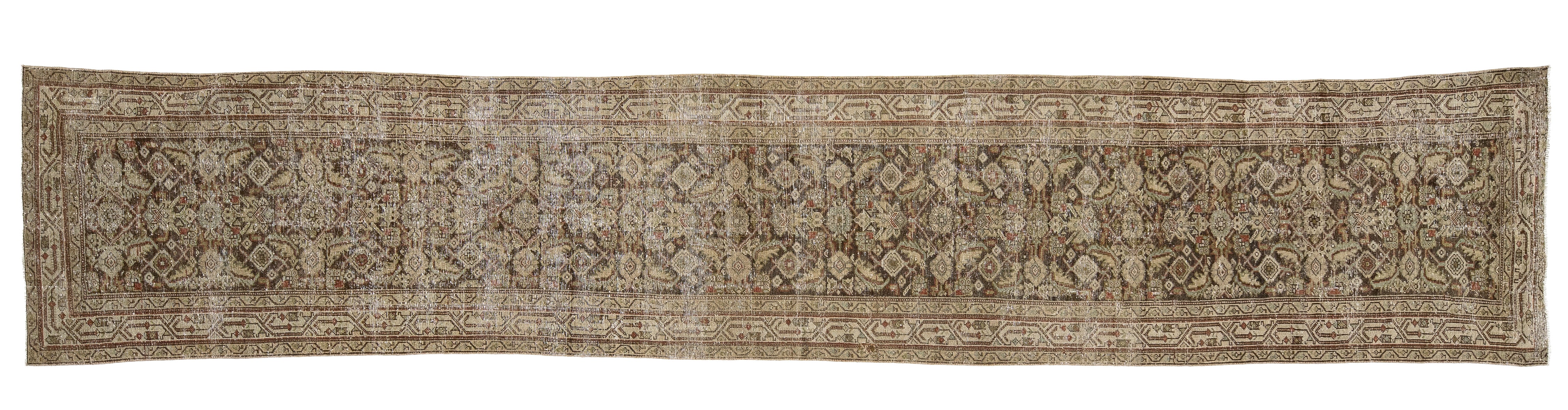 A long, narrow vintage-style area rug with an intricate traditional floral and geometric pattern in muted beige, brown, and gray tones.