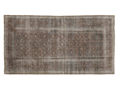 A rectangular distressed area rug with a faded traditional pattern in muted brown, gray, beige, and off-white tones, shown flat against a white background.