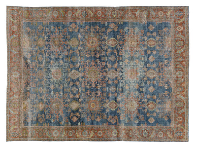 A distressed traditional area rug with an intricate floral pattern, featuring a dominant blue field, rust-orange borders, and beige accents.