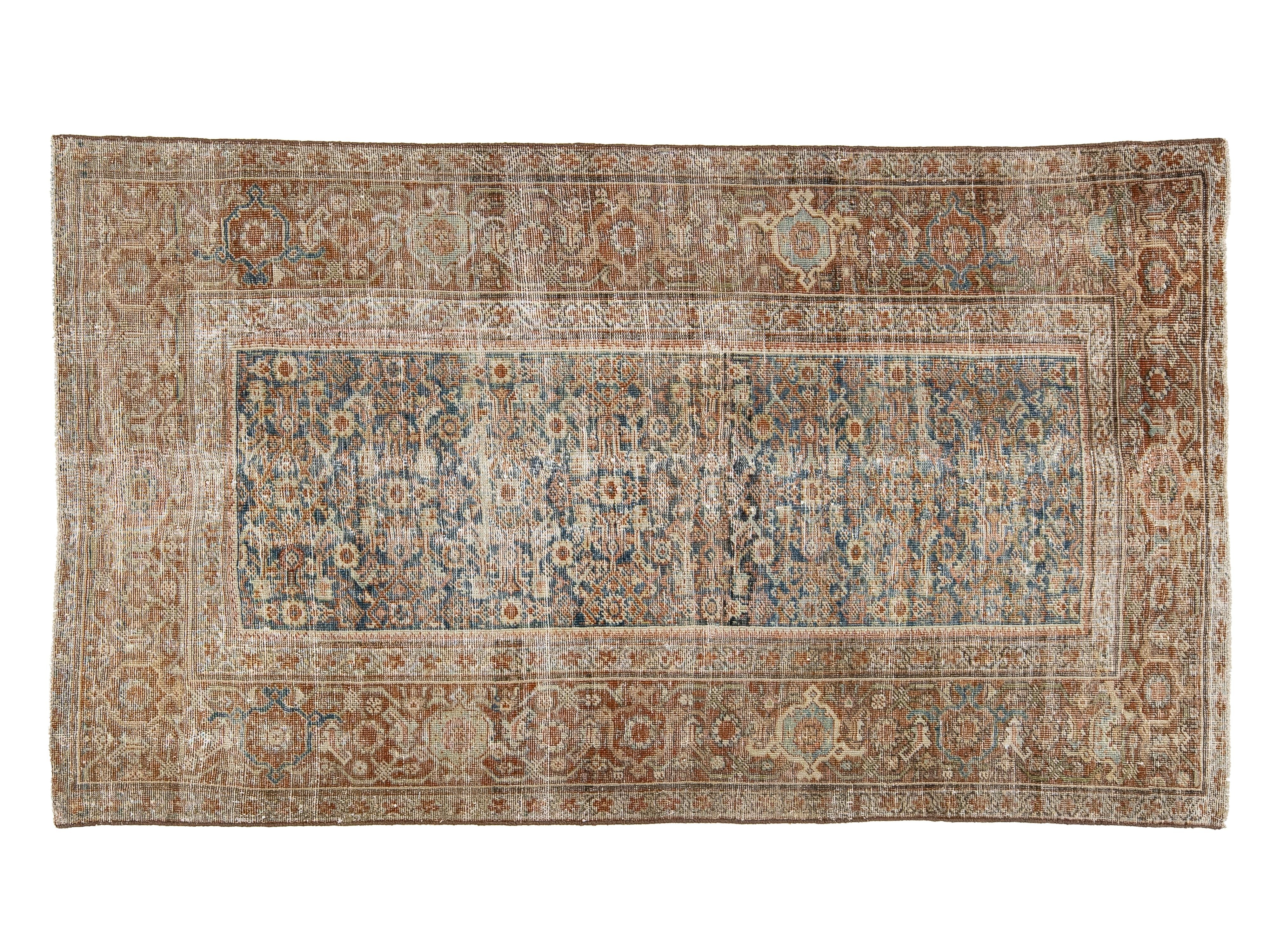 A rectangular vintage-style area rug with an intricate traditional pattern, featuring a central field in muted blue-gray tones surrounded by warm beige and brown borders.