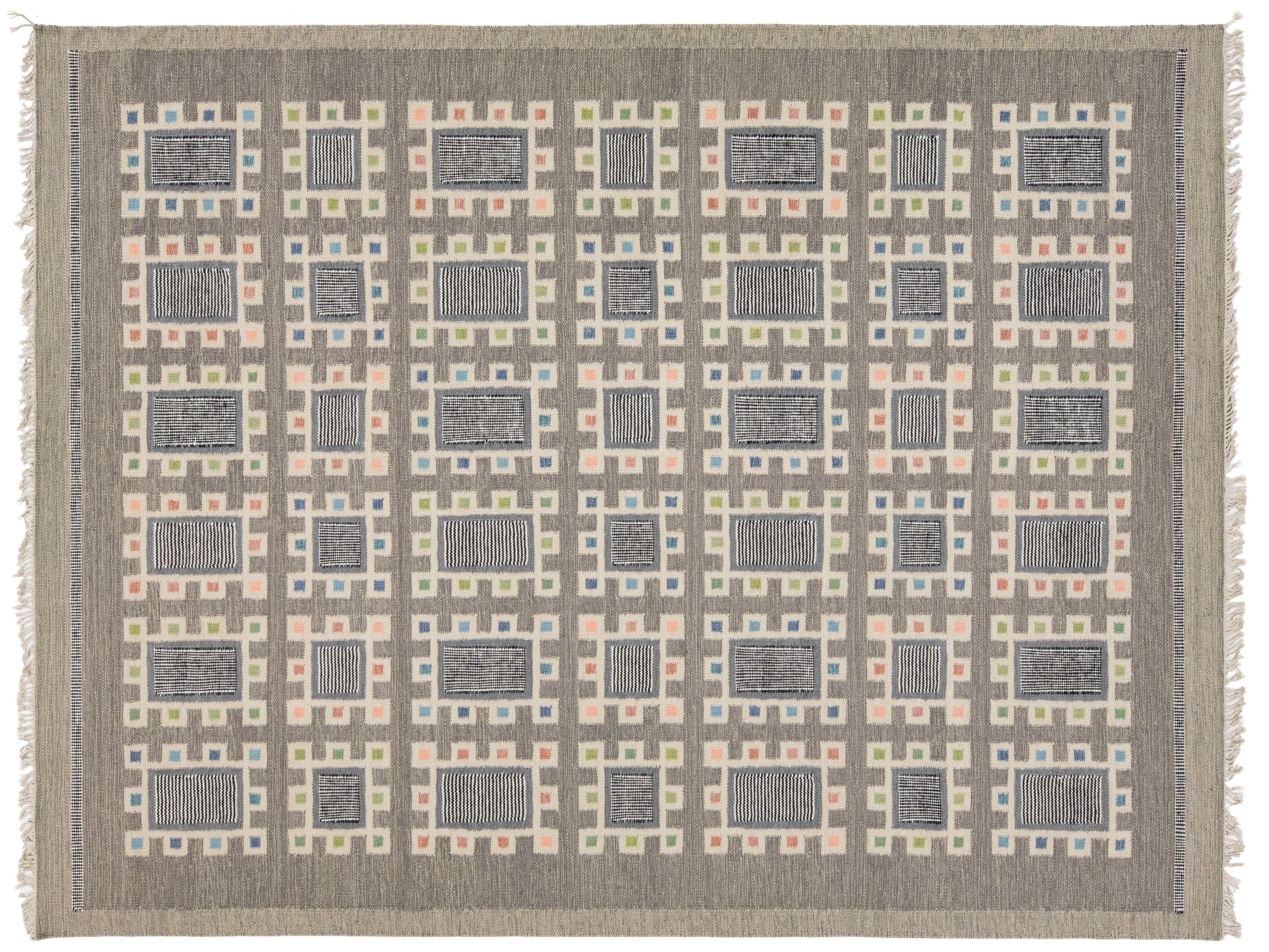 A rectangular woven area rug with a geometric grid pattern in shades of gray, beige, muted pink, and light blue, featuring a fringed border.