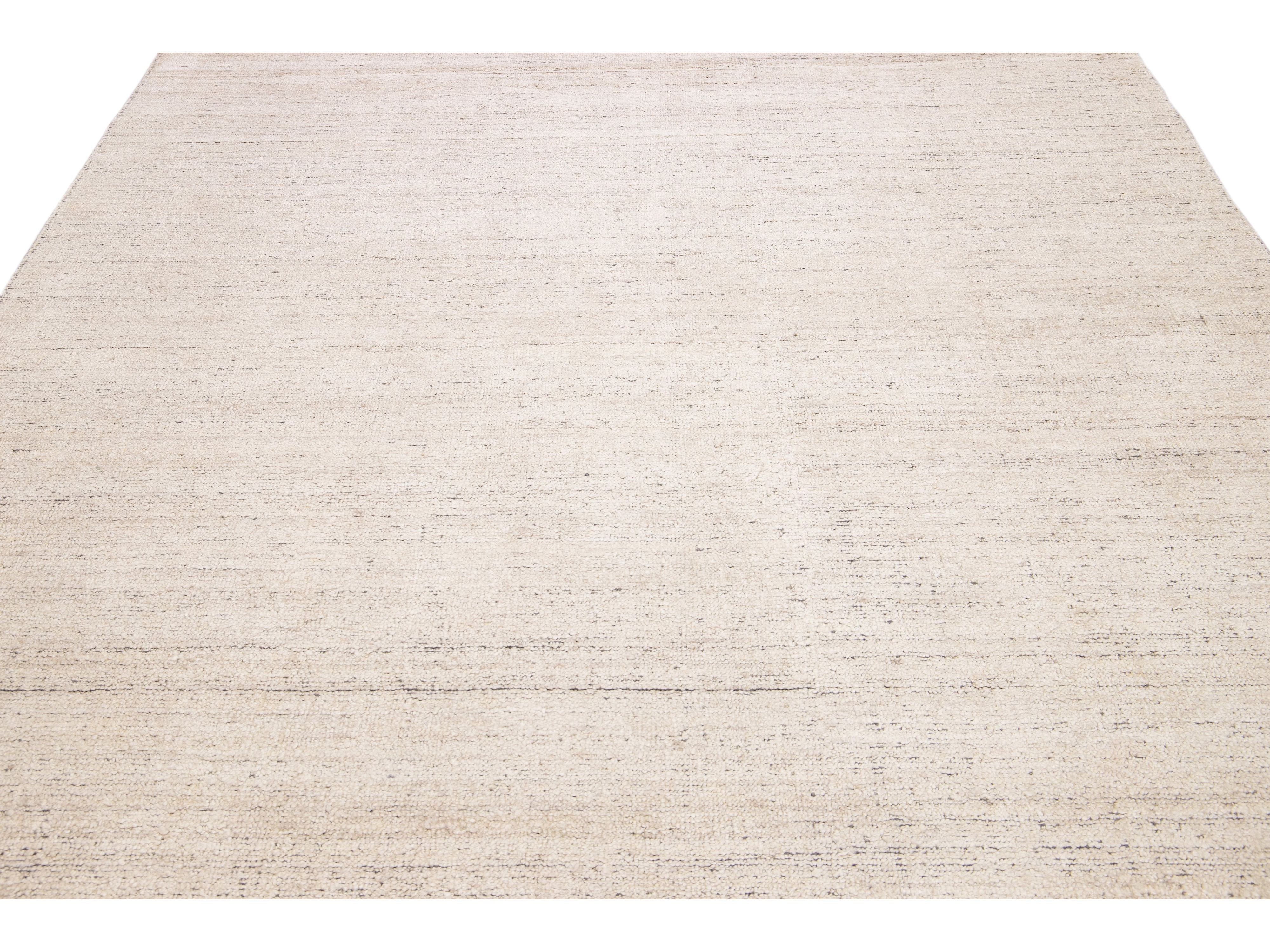 Beautiful Modern Delino hand-loom wool beige field. This piece has a gorgeous all-over solid design.  This rug measures 5' x 8'.  