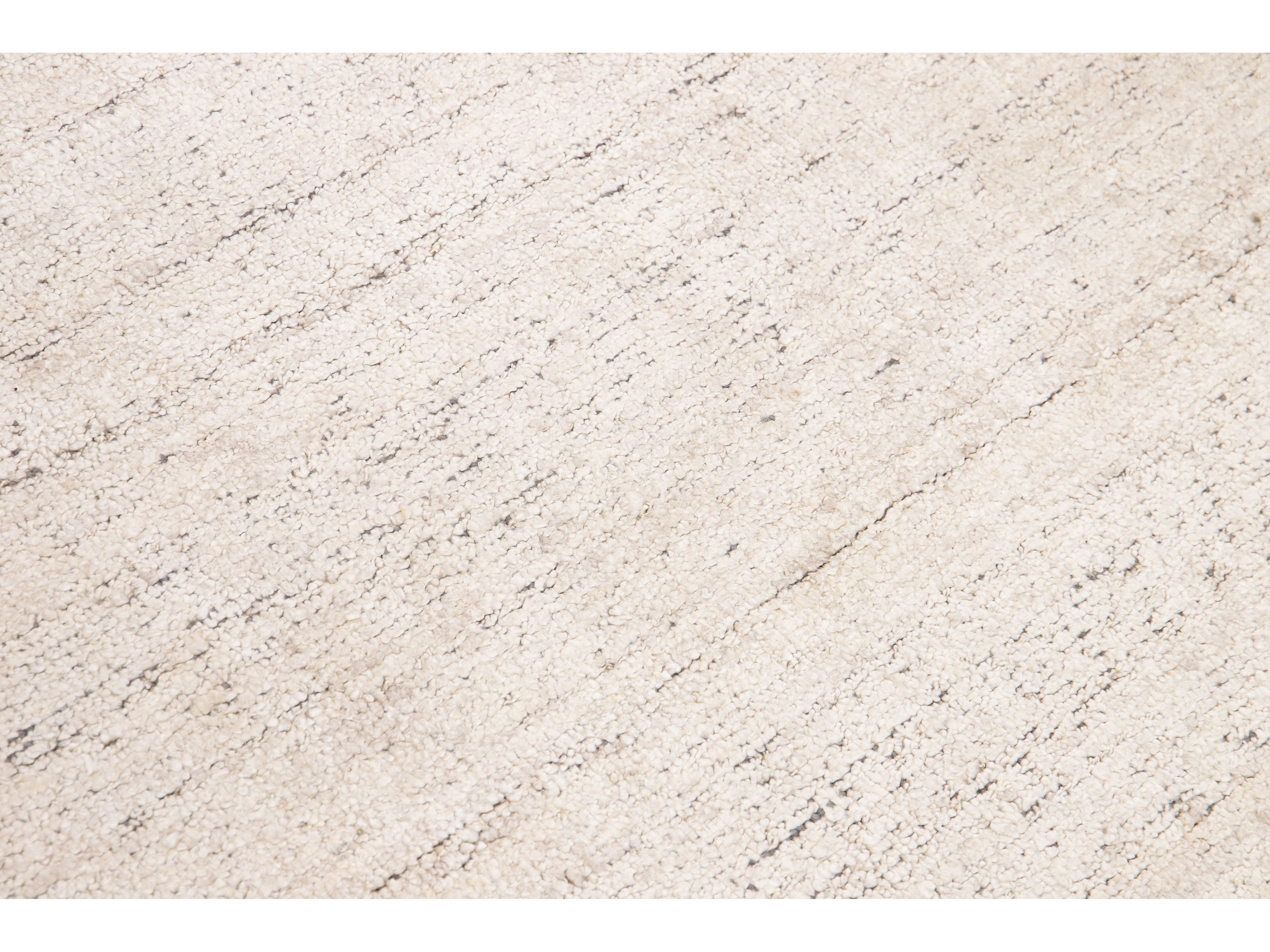 Beautiful Modern Delino hand-loom wool beige field. This piece has a gorgeous all-over solid design.  This rug measures 5' x 8'.  