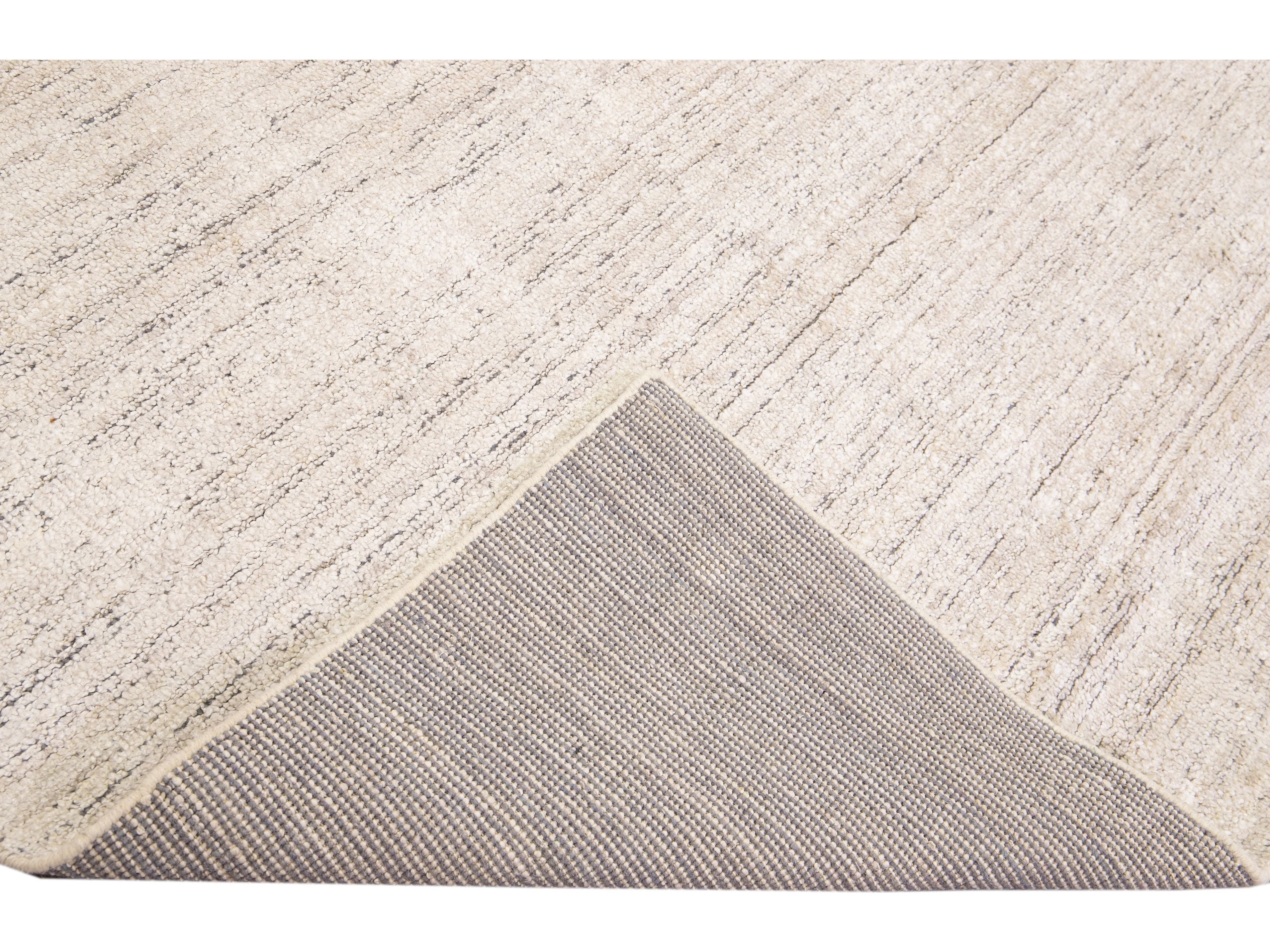 Beautiful Modern Delino hand-loom wool beige field. This piece has a gorgeous all-over solid design.  This rug measures 5' x 8'.  