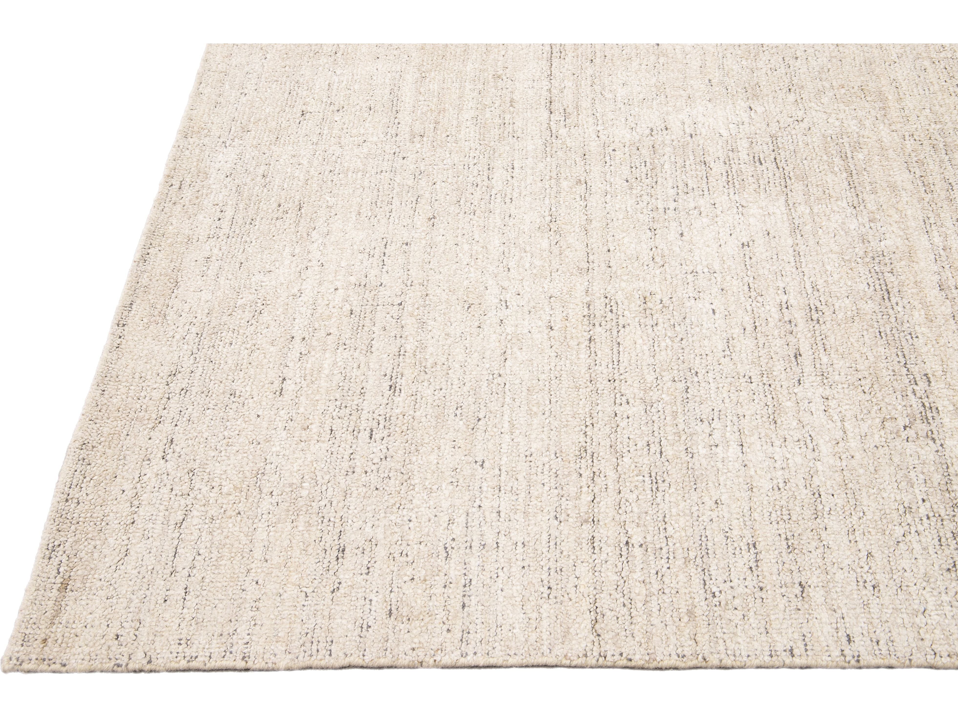 Beautiful Modern Delino hand-loom wool beige field. This piece has a gorgeous all-over solid design.  This rug measures 5' x 8'.  