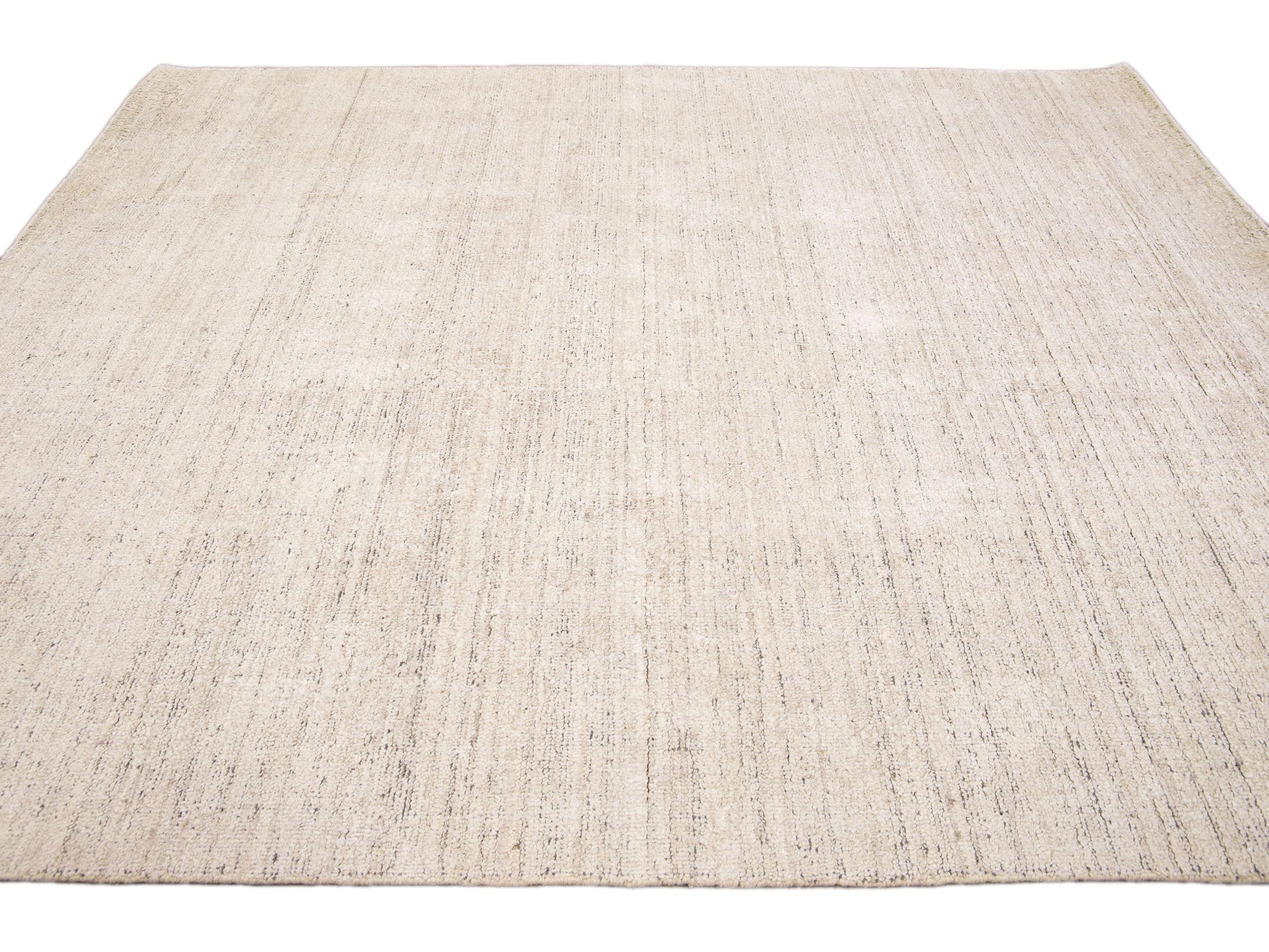 Beautiful Modern Delino hand-loom wool beige field. This piece has a gorgeous all-over solid design.  This rug measures 5' x 8'.  